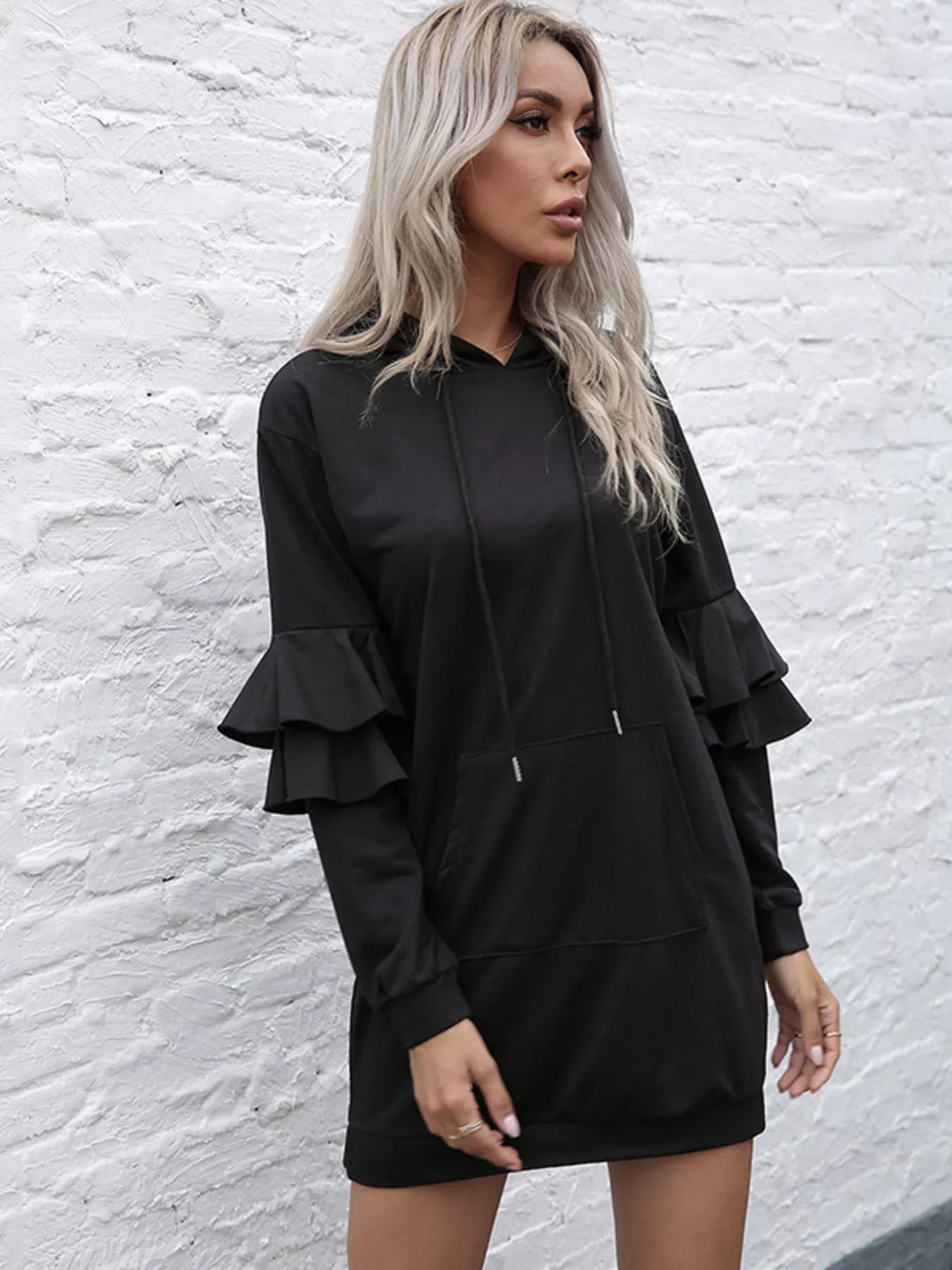 Black hooded mini dress with tiered ruffle sleeves and a front pocket.
