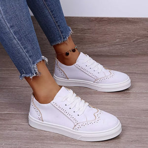 White matte finish lace-up sneakers with brogue detailing and gold stitching.