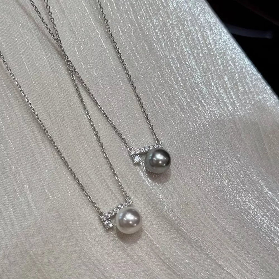 Lustrous pearl pendant necklaces with zircon accents in light gray and cream.