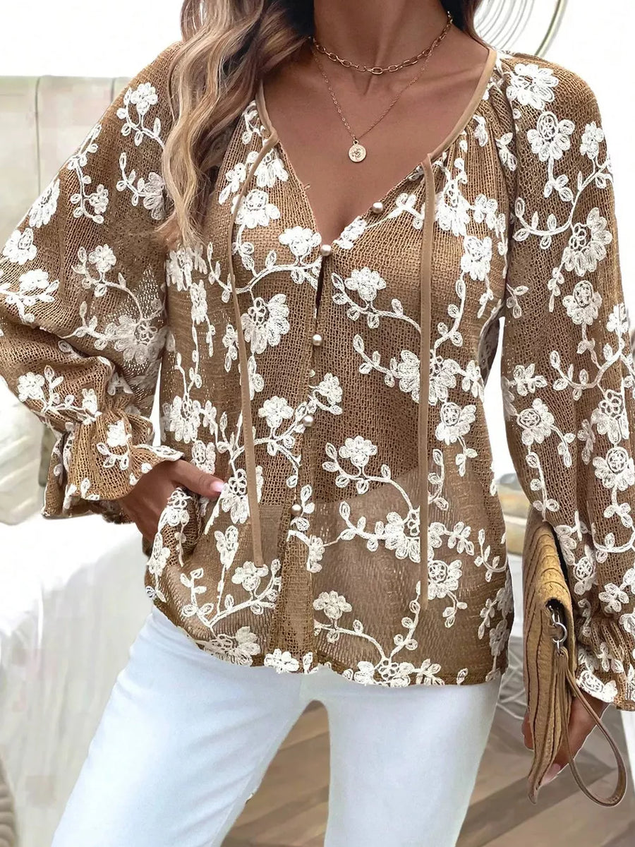 Coffee brown sheer long-sleeve blouse with white floral embroidery and pearl button detail.