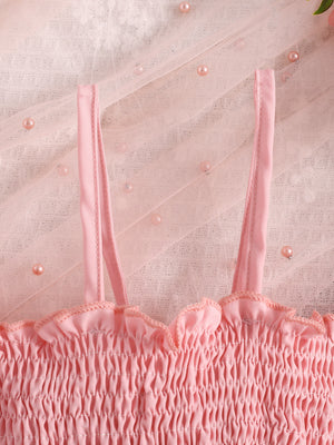 Pink smocked baby top with ruffled neckline and tulle overlay with pearls.