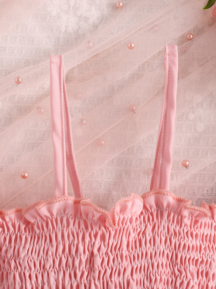 Pink smocked baby top with ruffled neckline and tulle overlay with pearls.