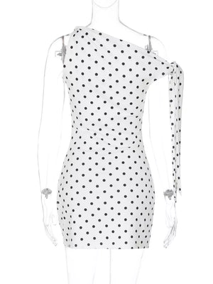 White polka dot mini dress with asymmetrical neckline and bow detail on sleeve.