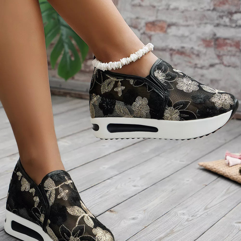 Black floral embroidered mesh slip-on sneakers with a chunky white platform sole.