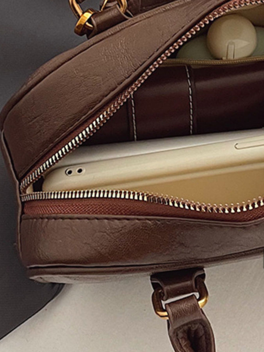 Brown pu leather crossbody bag with open zipper showing phone and interior.