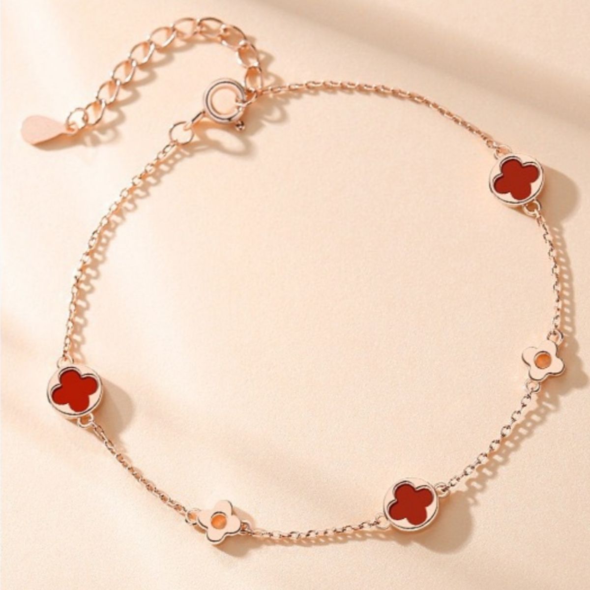 red bracelet featuring adjustable length and four-leaf clover motif