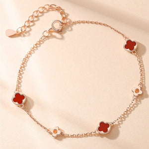 red bracelet featuring adjustable length and four-leaf clover motif