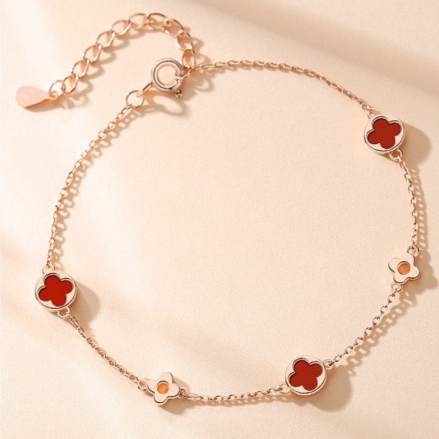 red bracelet featuring adjustable length and four-leaf clover motif