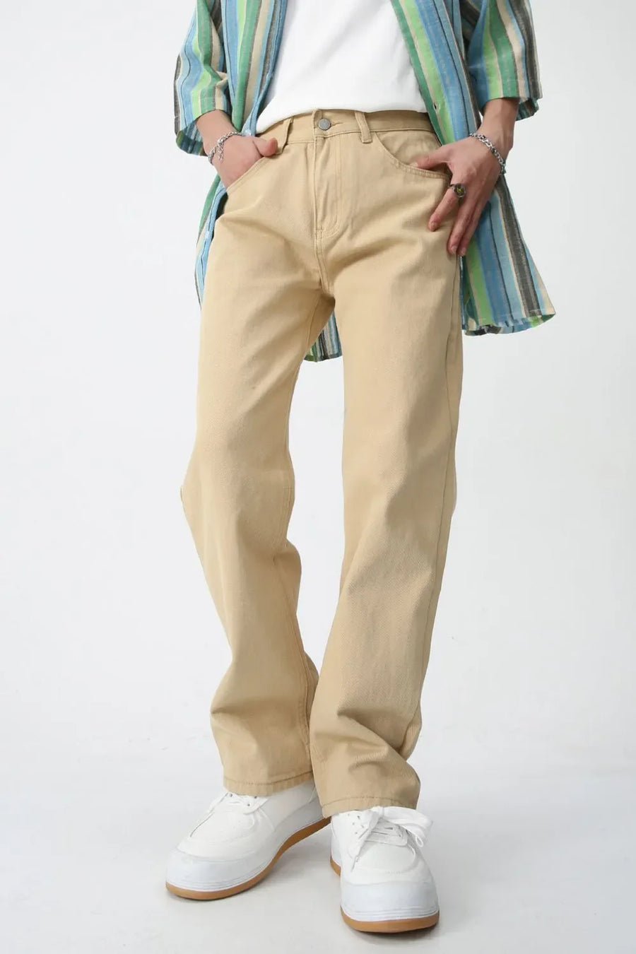 Relaxed fit khaki chino trousers with a straight leg, styled with a striped shirt and white sneakers.