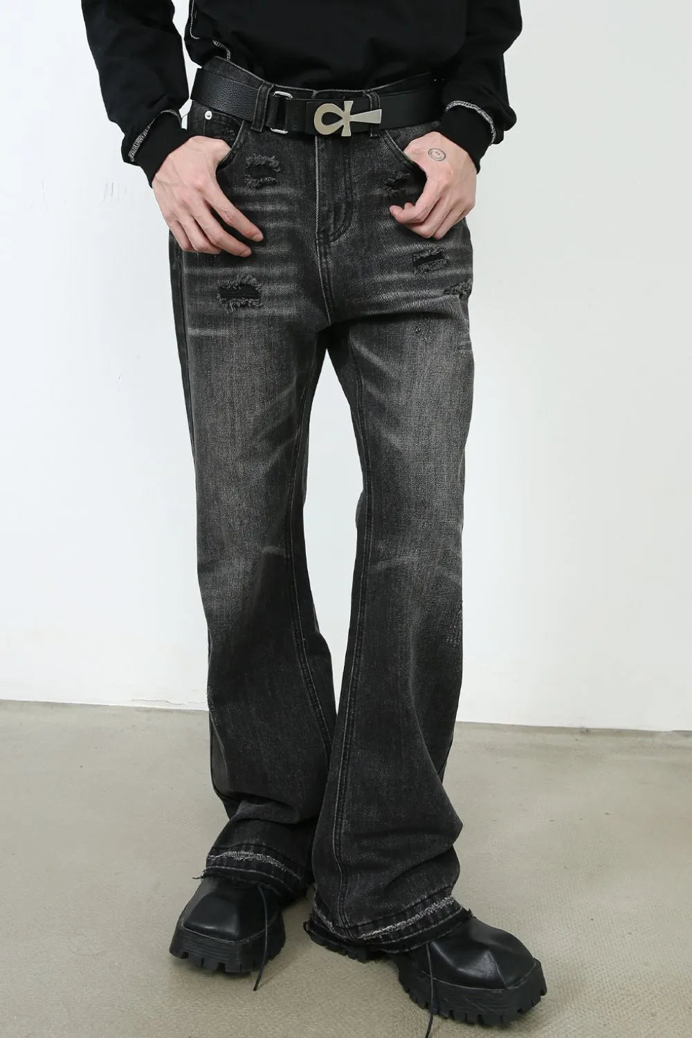 Distressed flare jeans in washed black denim with ripped details and a bootcut leg.