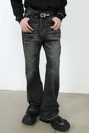 Distressed flare jeans in washed black denim with ripped details and a bootcut leg.