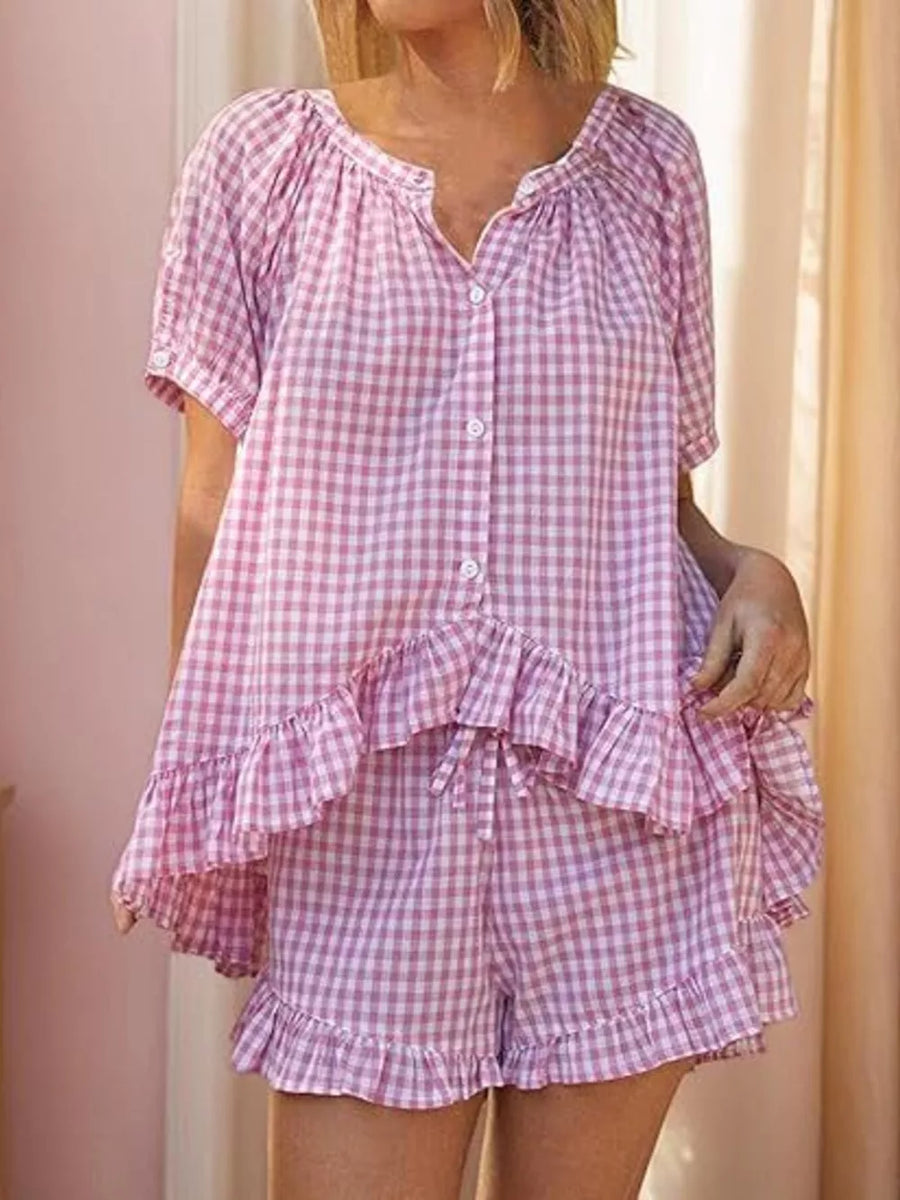 Pink gingham ruffle-trimmed two-piece pajama set with button-front top and drawstring shorts.