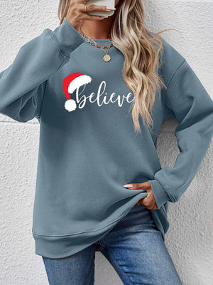 Light Blue raglan sweatshirt with "Believe" and Santa hat graphic, crewneck, casual style.