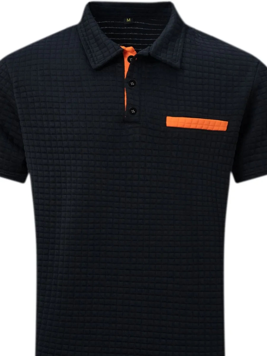 Navy textured polo shirt with orange contrast pocket and placket detail.