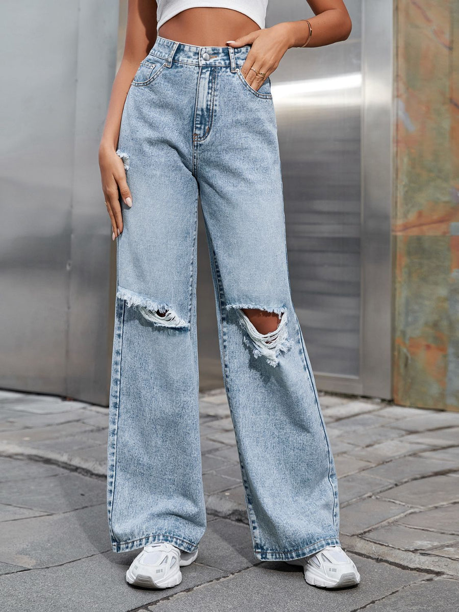 Light wash distressed denim jeans with ripped knees and a wide leg cut.