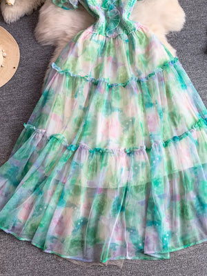 Floral tiered midi dress in light green with smocked bodice and ruffled tiers.