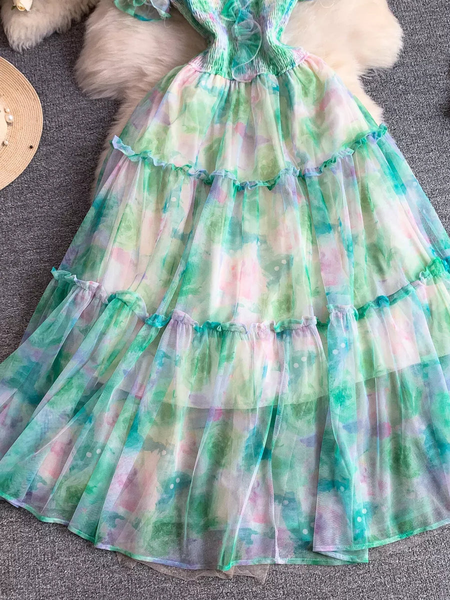 Floral tiered midi dress in light green with smocked bodice and ruffled tiers.