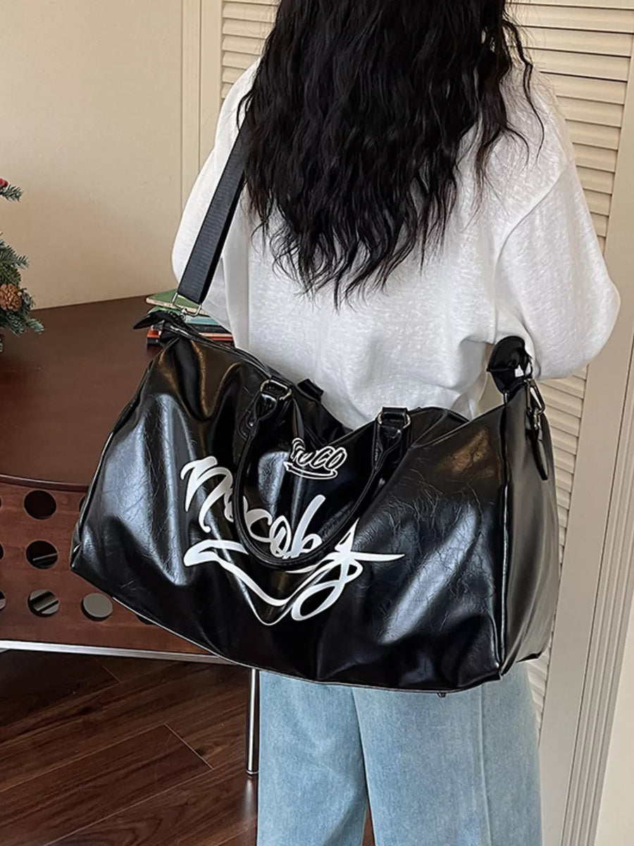 Sleek black PU leather travel bag with white script logo and shoulder strap.