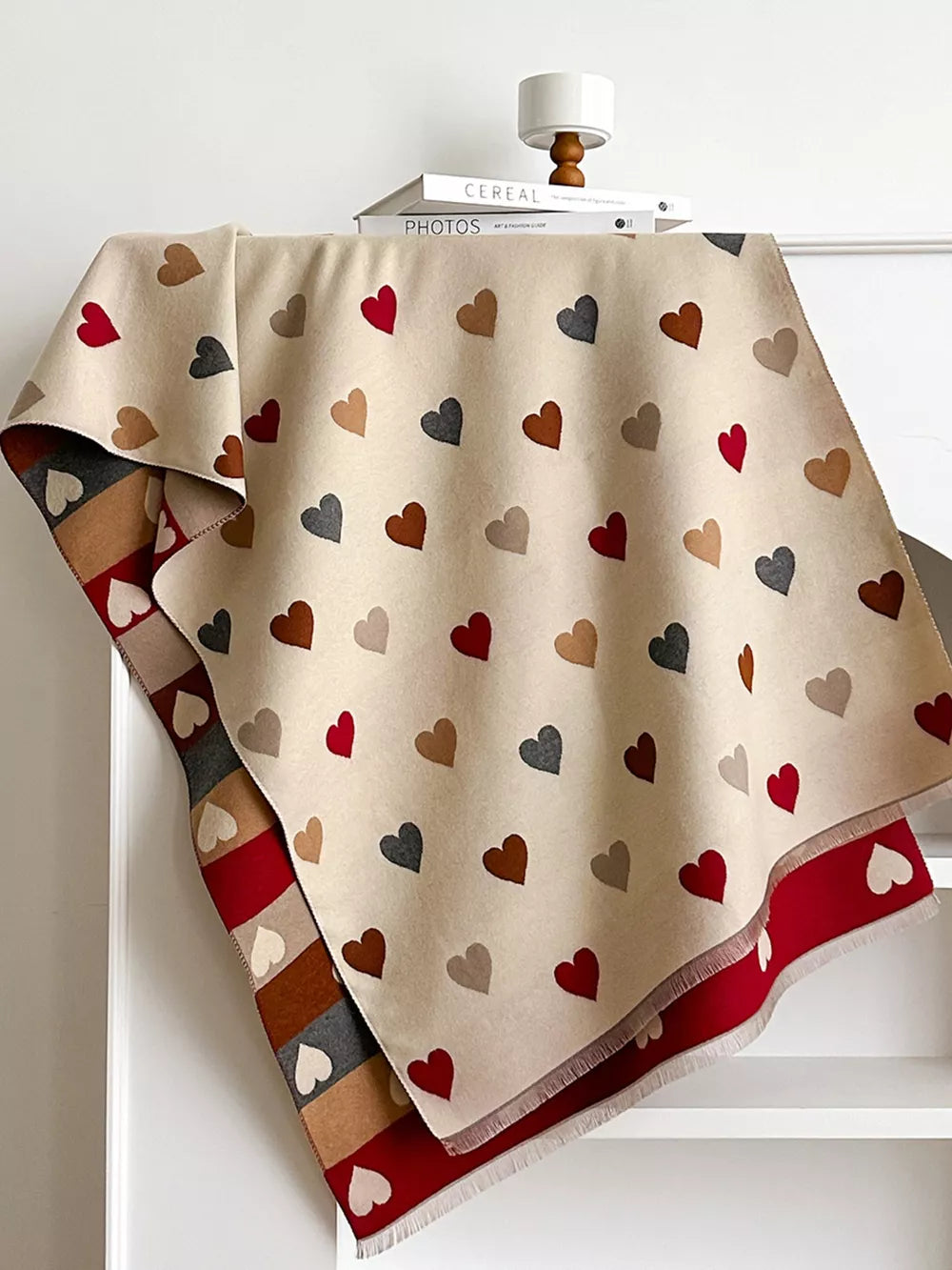 Cozy scarf in beige with scattered red, brown, and gray hearts. Red border with white hearts.