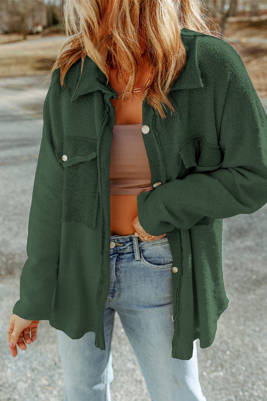 Green button-up coat with textured fabric and chest pockets.