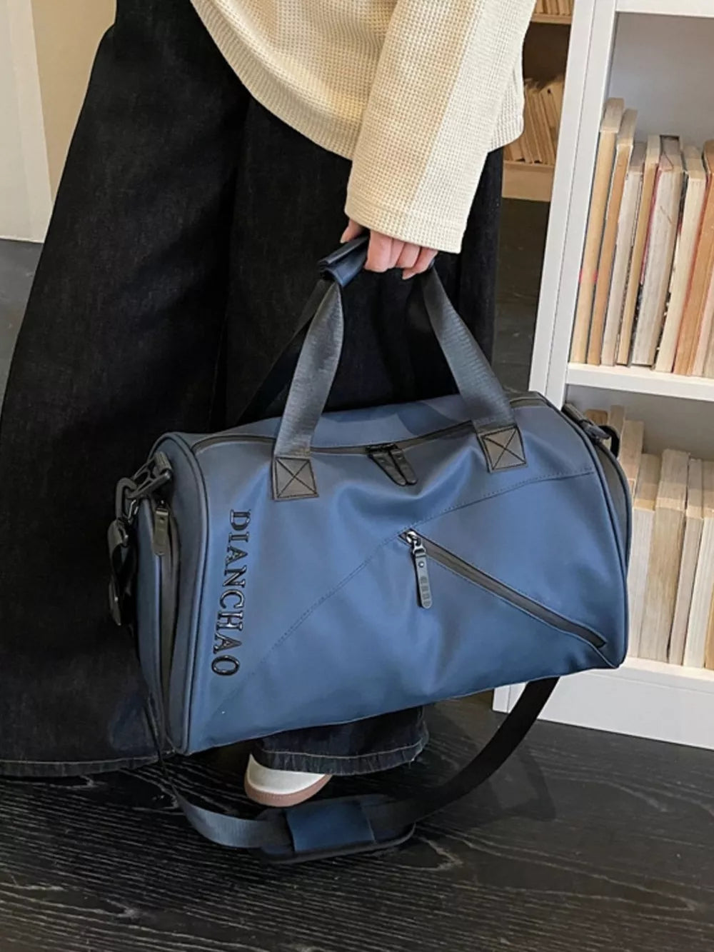Blue travel organizer bag with padded strap and multiple zippered pockets.