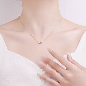 Gold bean pendant necklace on a delicate box chain, sterling silver.