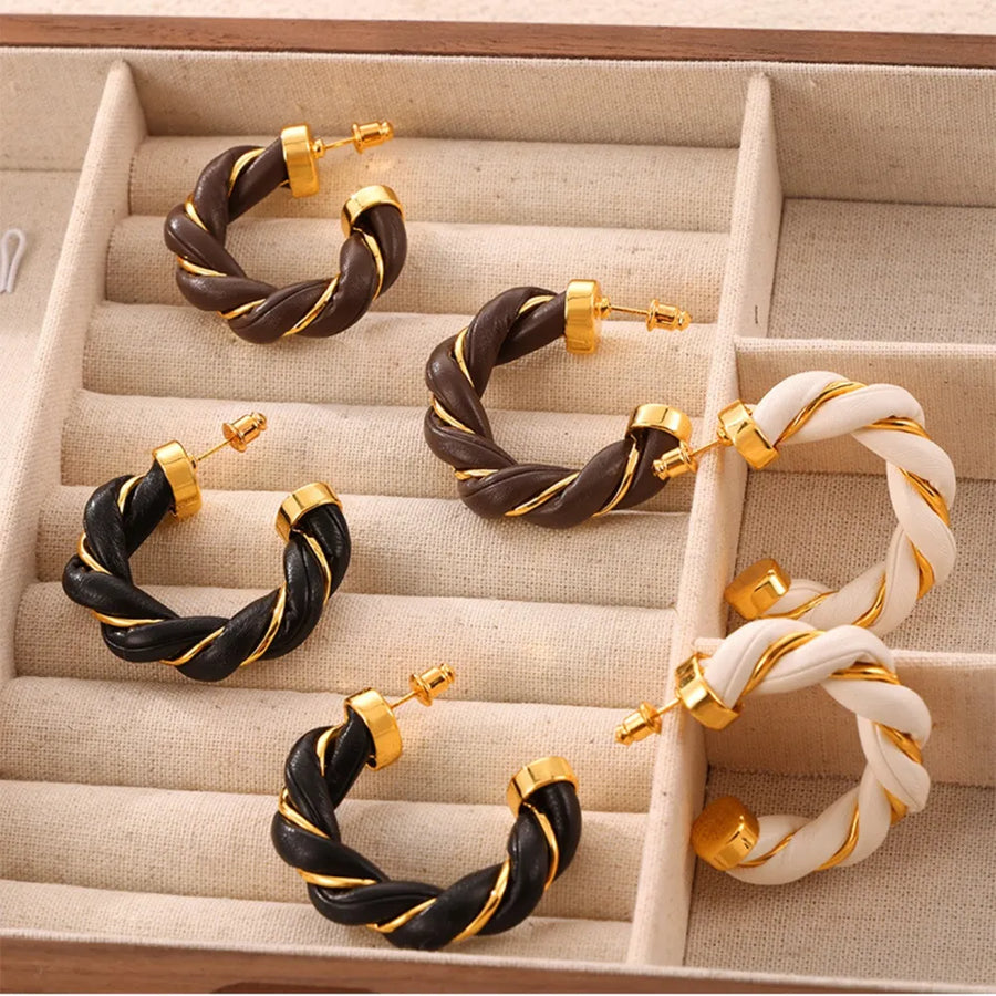 Braided leather and gold hoop earrings in black, coffee brown, and white.