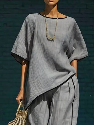 Gray two-piece set with contrast trim, featuring a relaxed top and cropped pants.