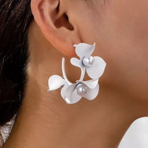 White floral pearl hoop earrings with delicate petals and pearl accents.