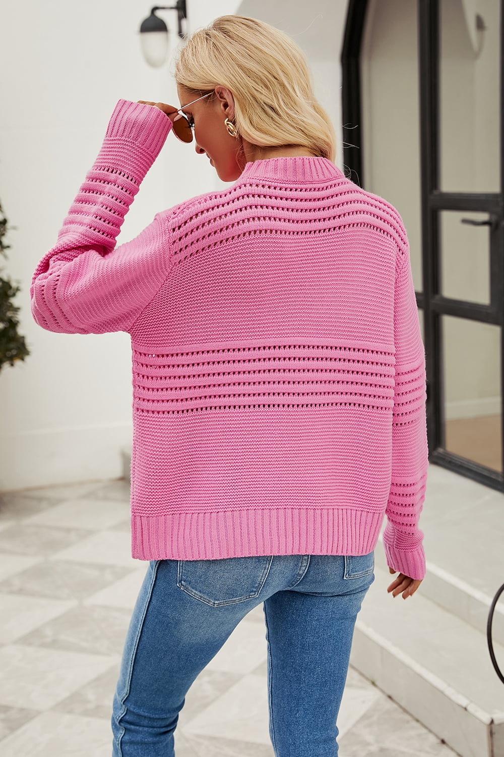 Pink open-knit mock neck sweater with horizontal open-knit details on back and sleeves.