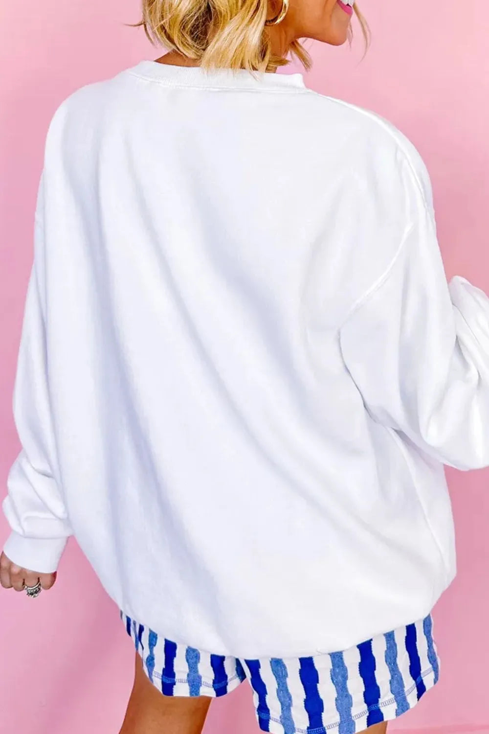 White crewneck sweatshirt with distressed American flag detail.