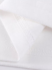 White cotton girls' undershirt detail showing stitching and fabric texture.