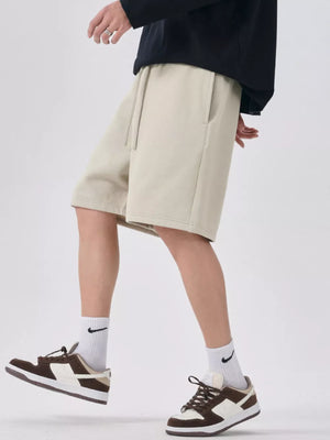 Beige chino shorts with drawstring waist and side pockets, relaxed fit.