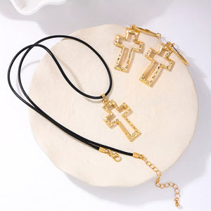 Golden cross pendant necklace with black cord and matching earrings, 18K gold-plated.