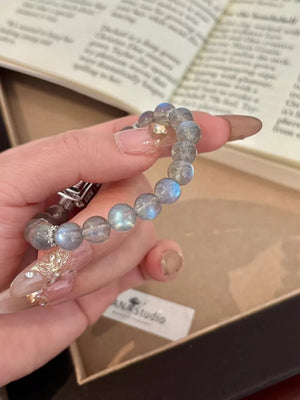 Iridescent moonstone beaded bracelet with silver accents and geometric details.