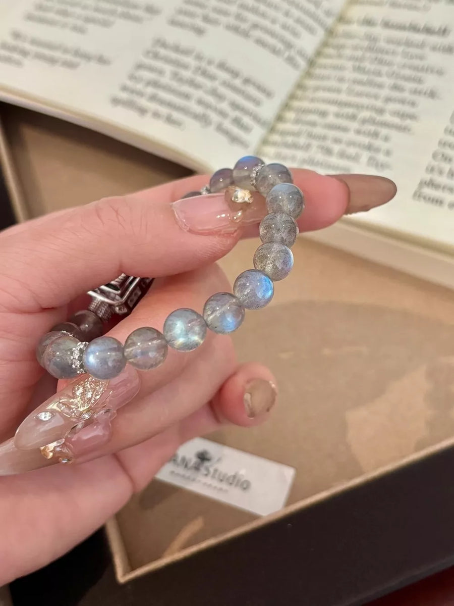 Iridescent moonstone beaded bracelet with silver accents and geometric details.