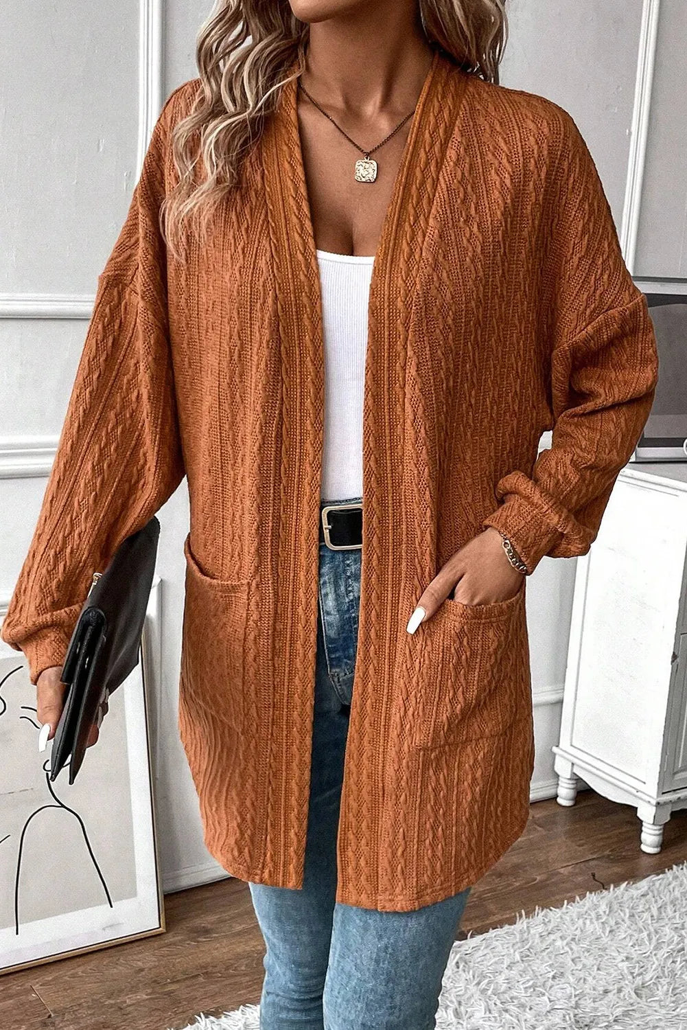 Terracotta open front cardigan with cable knit texture and pockets.