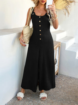 Black linen wide-leg jumpsuit with button front and wide straps.