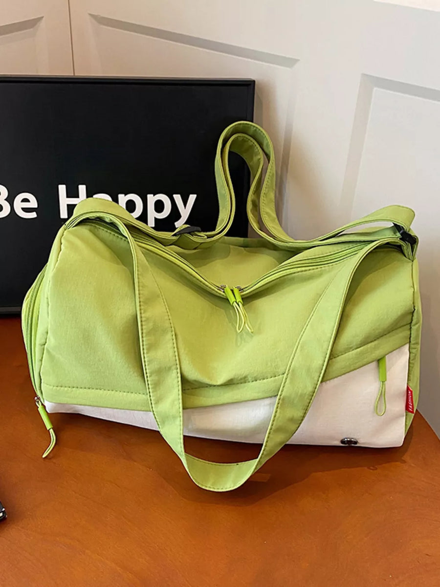 Vibrant color-block nylon travel bag with green and white panels and adjustable strap.