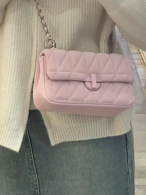 Pink quilted mini flap chain bag with a silver chain strap and a round clasp.