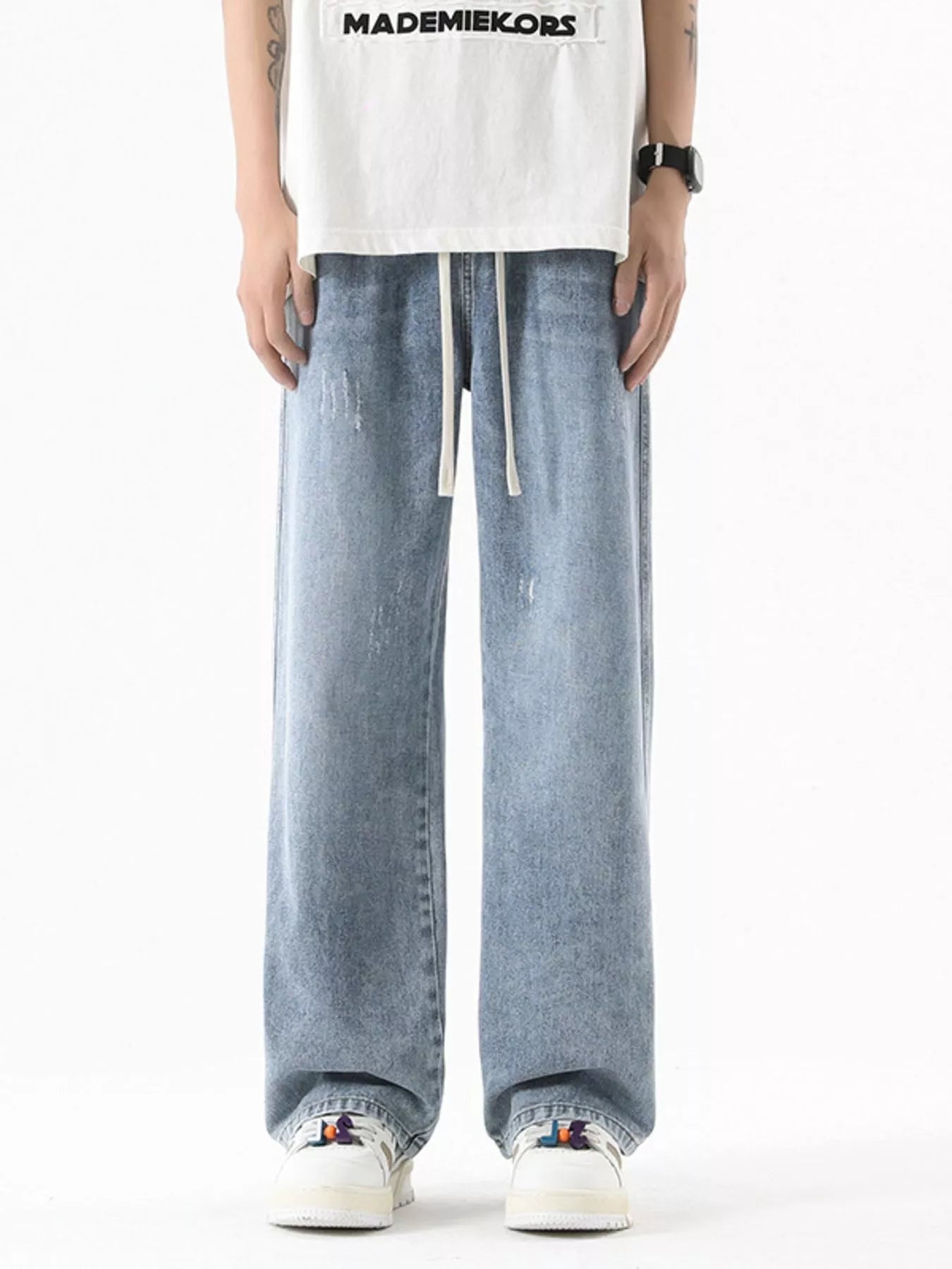 Light blue vintage wash oversized wide-leg jeans with drawstring and distressed details.