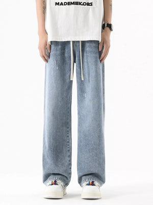 Light blue vintage wash oversized wide-leg jeans with drawstring and distressed details.