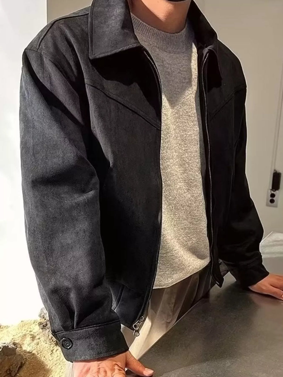 Black zip-up casual jacket with a collar and button cuff, styled over a grey sweater.