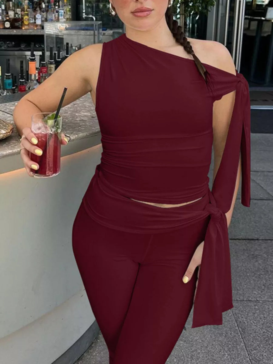 Burgundy asymmetrical one-shoulder top with tie detail and capri pants set.