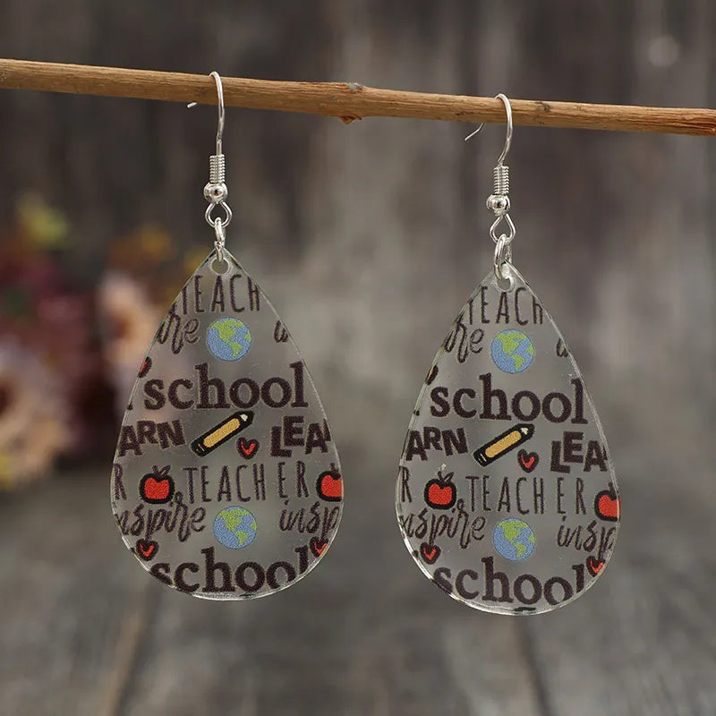 Schoolhouse graphic teardrop acrylic earrings with teacher, school, and apple designs.