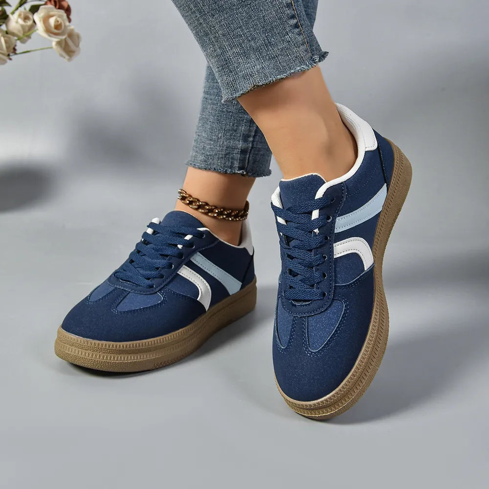 Dark blue lace-up sneakers with contrast white and light blue stripes and a gum sole.