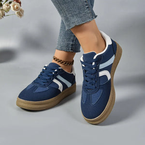 Dark blue lace-up sneakers with contrast white and light blue stripes and a gum sole.