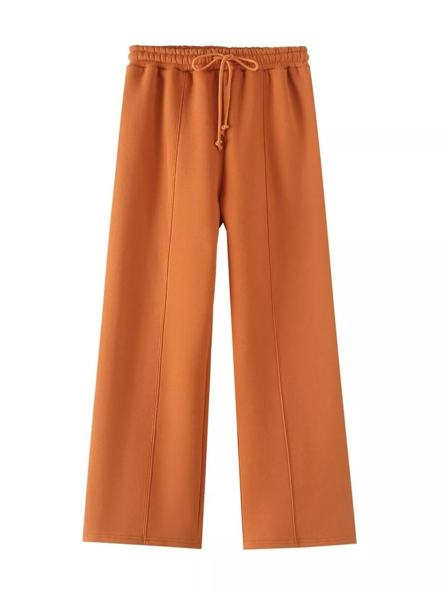 Orange casual wide-leg pants with drawstring waist and seam detail.
