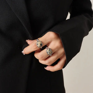 Silver rings with square natural stone settings, one with black speckles.
