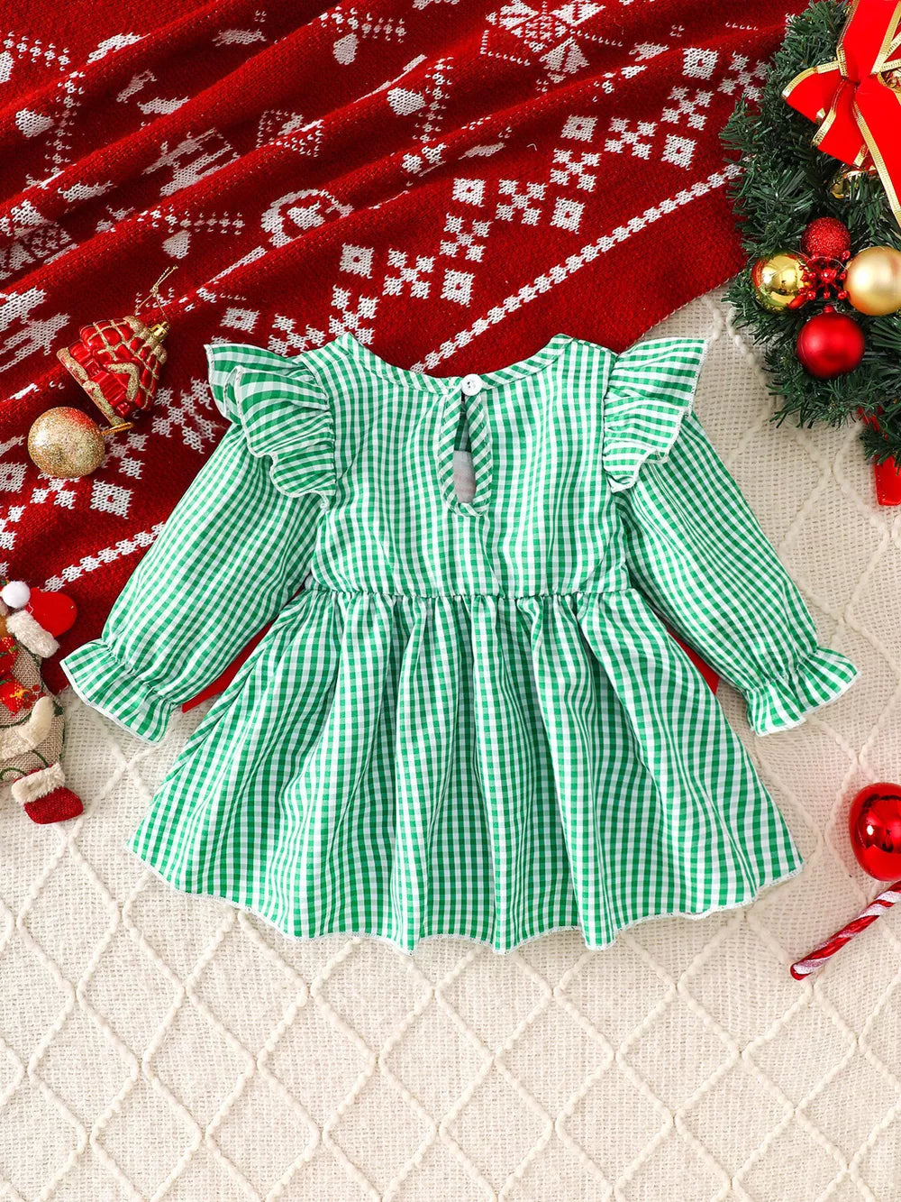 Green gingham baby dress with ruffled sleeves and a gathered skirt.